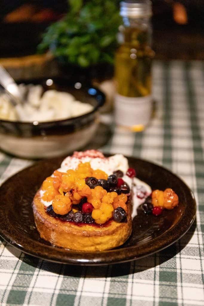 fried bread dessert with berries and whip cream on top