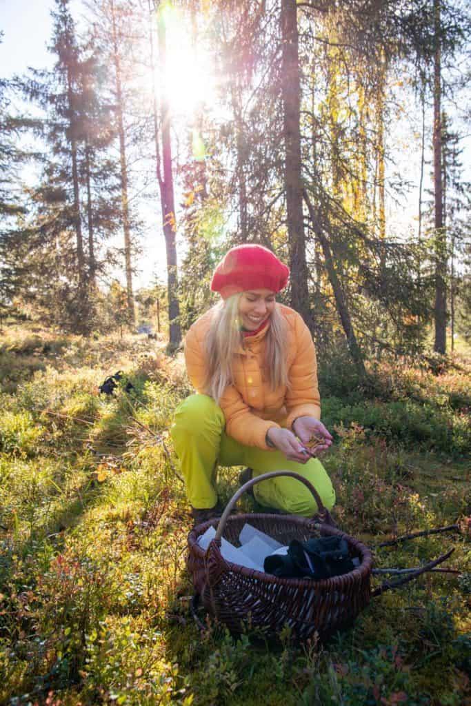 a woman in the forest picking berries