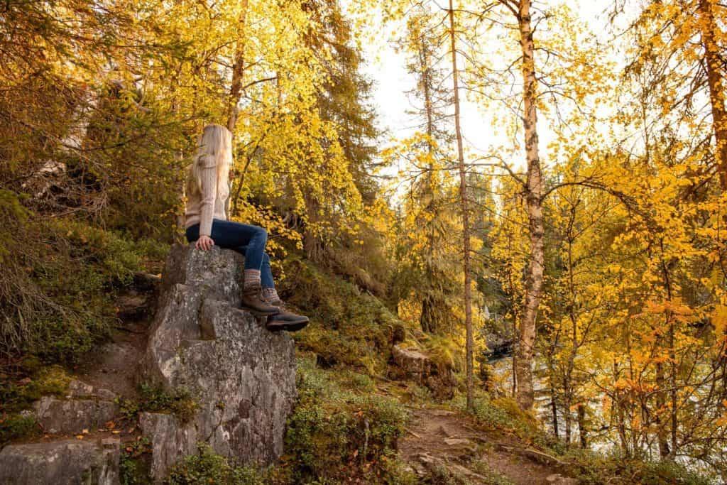 woman sitting in a green and yellow force overlooking a river