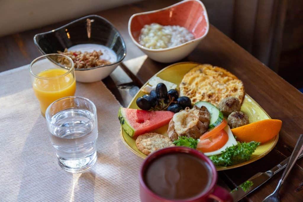 dishes and cups on a table including breakfast items and coffee